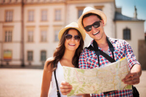 Happy tourists couple holding map