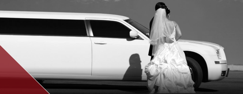 a newlywed couple in front of a stretch limousine